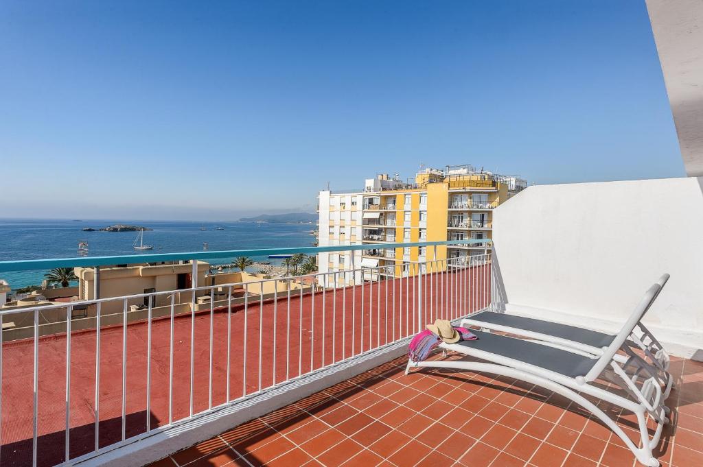 una sedia su un balcone con vista sull'oceano di Hotel Vibra Vila a Ibiza Città