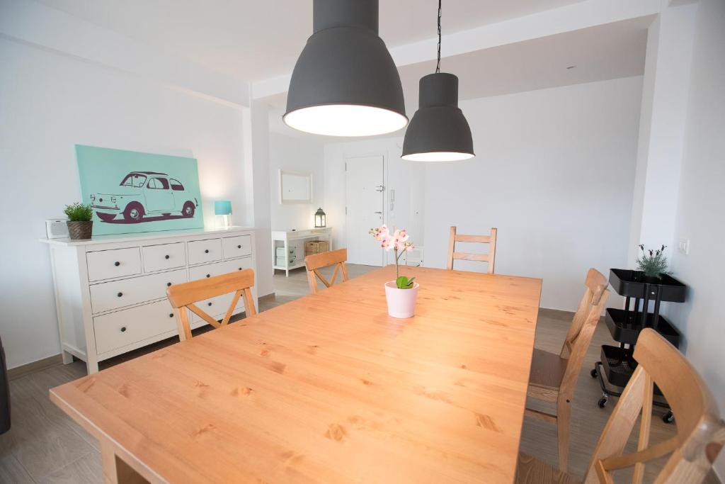 una cucina e una sala da pranzo con tavolo e sedie in legno di Apartamento cerca del mar (parking incluido) a Blanes