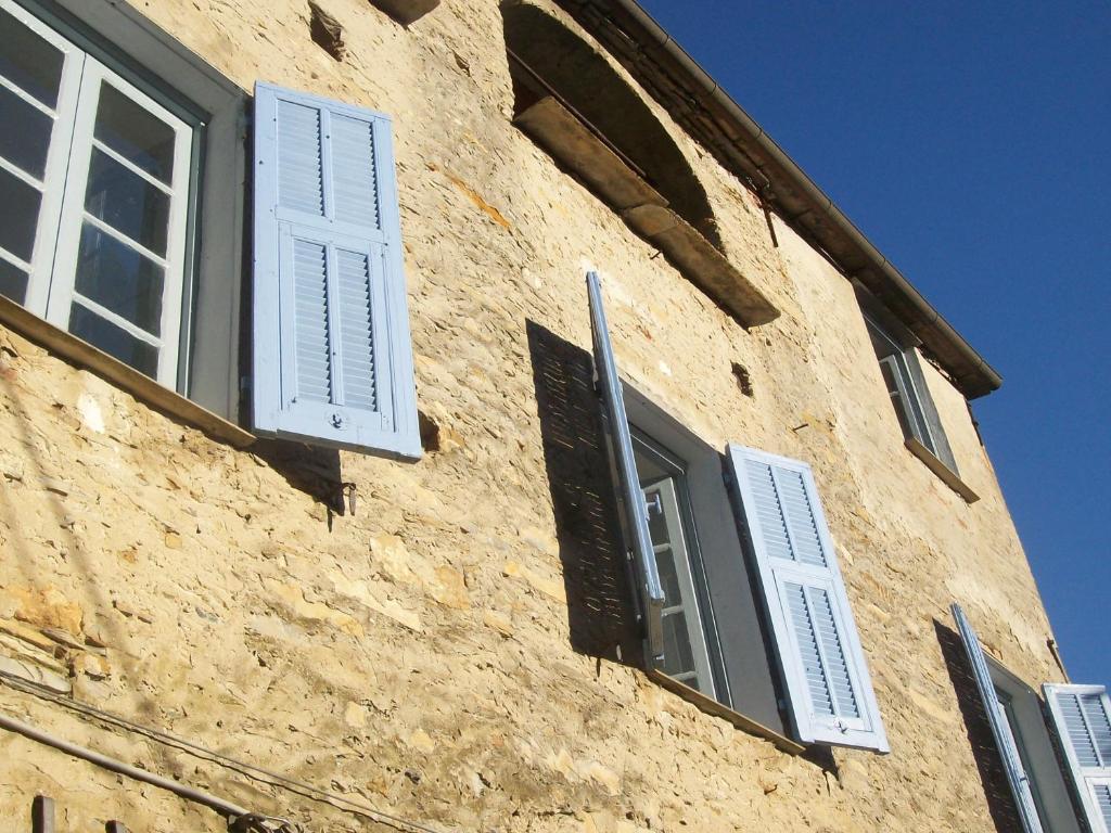 a building with white shuttered windows on it at B&B Ududemà in Dolcedo
