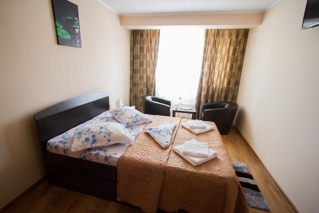 a bedroom with a bed with a table and a window at Casa Mara in Tulcea