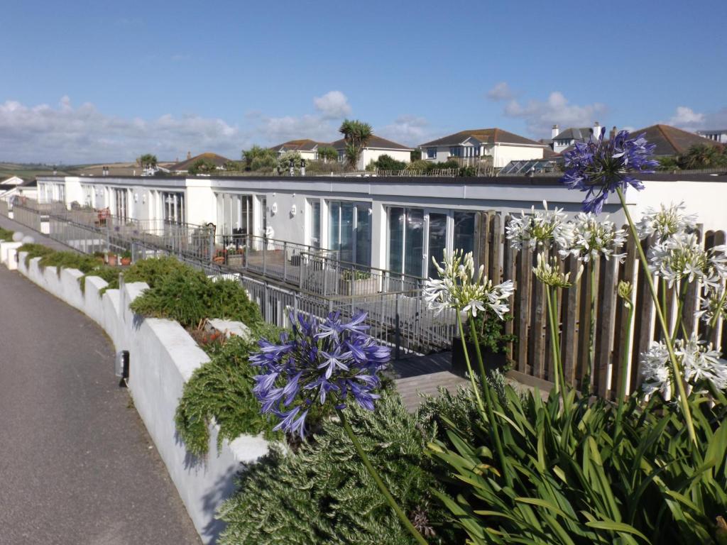 a row of houses with flowers and a fence at Ohana House in Newquay