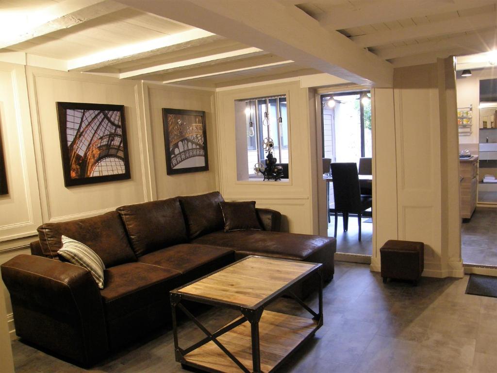 uma sala de estar com um sofá castanho e uma mesa em Honfleur de lys em Honfleur