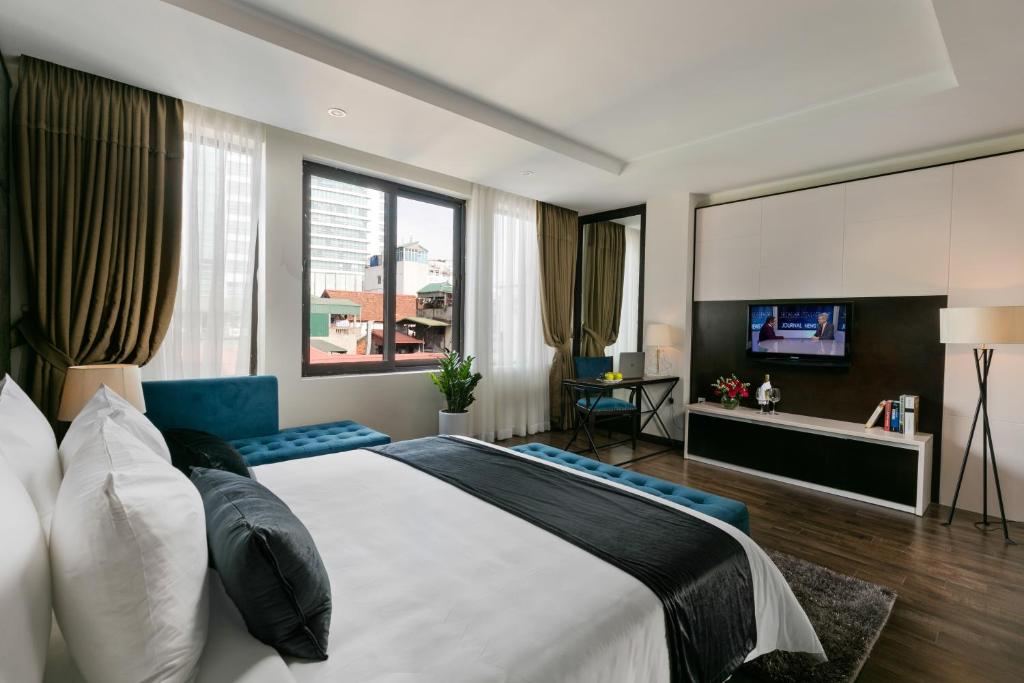1 dormitorio con 1 cama grande y TV en La Santé Hotel & Spa, en Hanói
