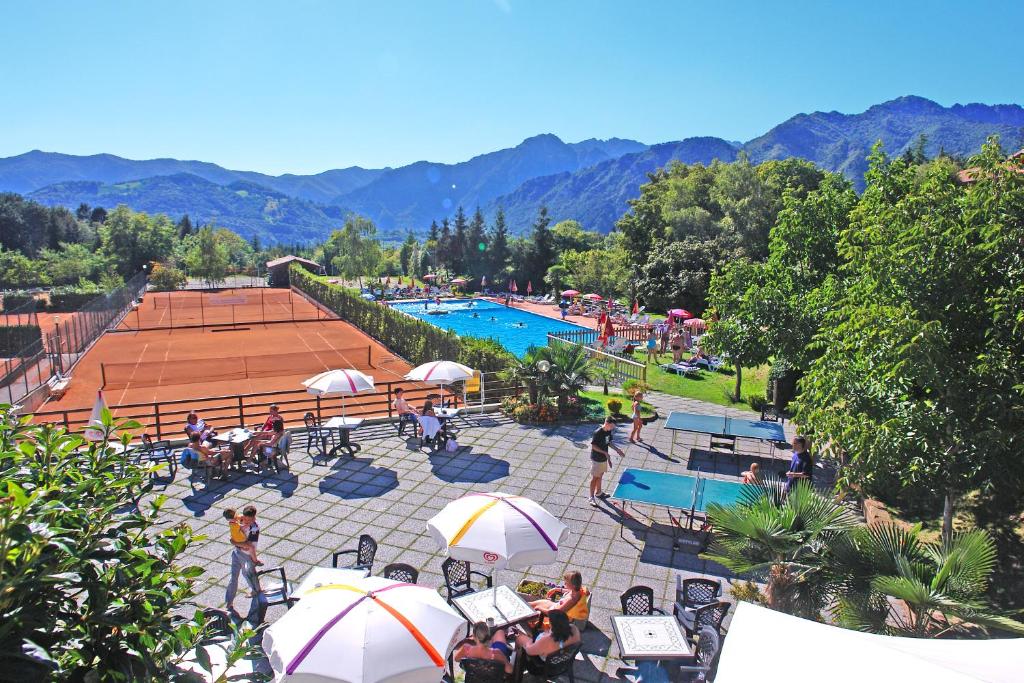 uma vista superior de uma piscina com pessoas sentadas sob guarda-sóis em Hotel Residence Campi em Tremosine Sul Garda