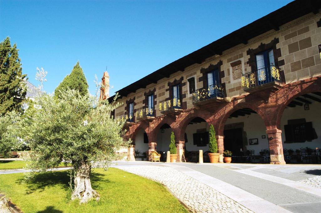 a building with a tree in front of it at Hotel Monumento Pazo do Castro in O Barco de Valdeorras