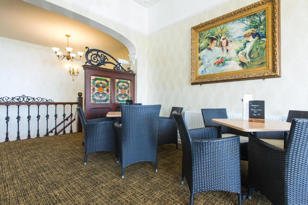 a restaurant with blue chairs and a painting on the wall at Hotel Balmoral in Bournemouth