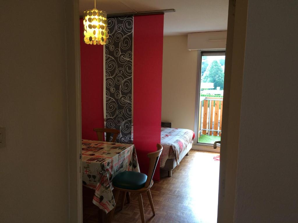 a room with a bed and a table and a window at Appartement vue sur lac in Gérardmer