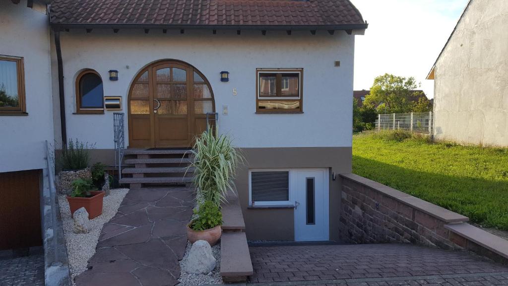 ein Haus mit einer Tür und einer Topfpflanze davor in der Unterkunft Ferienhaus Schwörer in Rheinhausen