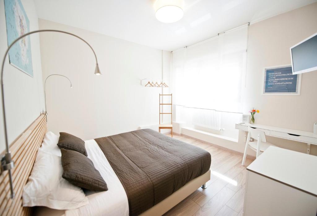 a bedroom with a large bed and a desk and a desk at B&B Lo Studio in LʼAquila
