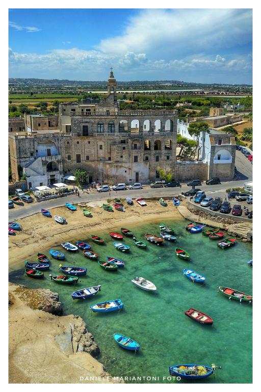 a bunch of boats in the water near a building at Hotel San Giovanni in Polignano a Mare