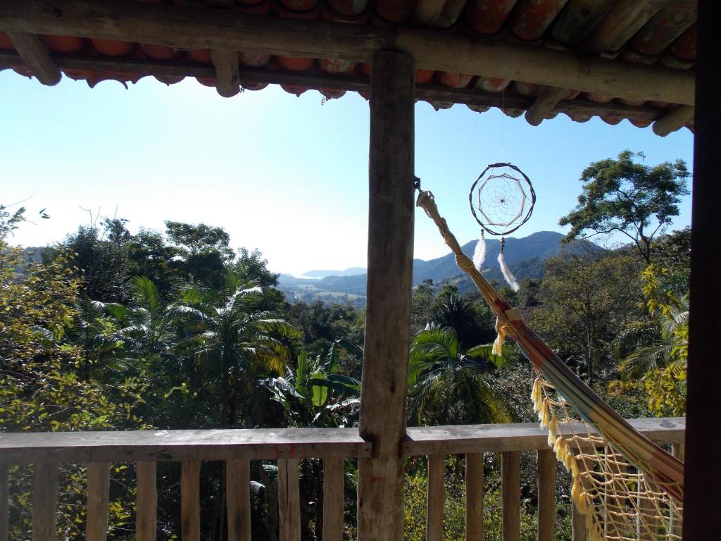 a hammock on a porch with a view of the mountains at Sítio Cumuru in Paraty