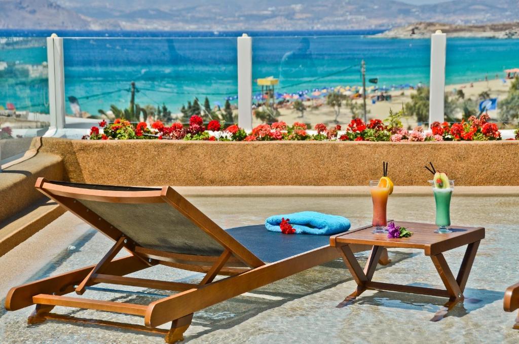 una silla de madera sentada junto a una mesa con velas en Naxos Island Hotel, en Agios Prokopios