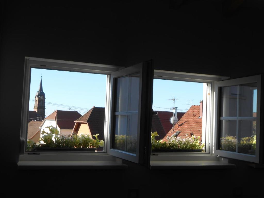 2 Fenster mit Blick auf eine Kirche in der Unterkunft Le Haut de l'Espérance in Uffholtz