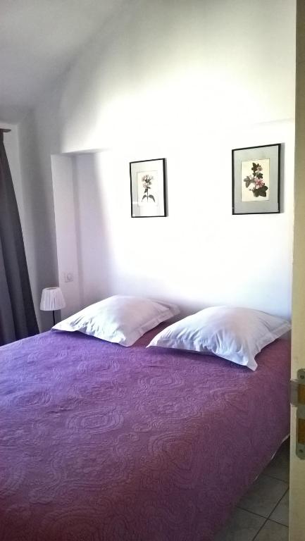 - une chambre avec un lit doté de draps et d'oreillers violets dans l'établissement Le Grenier Maufoux, à Beaune