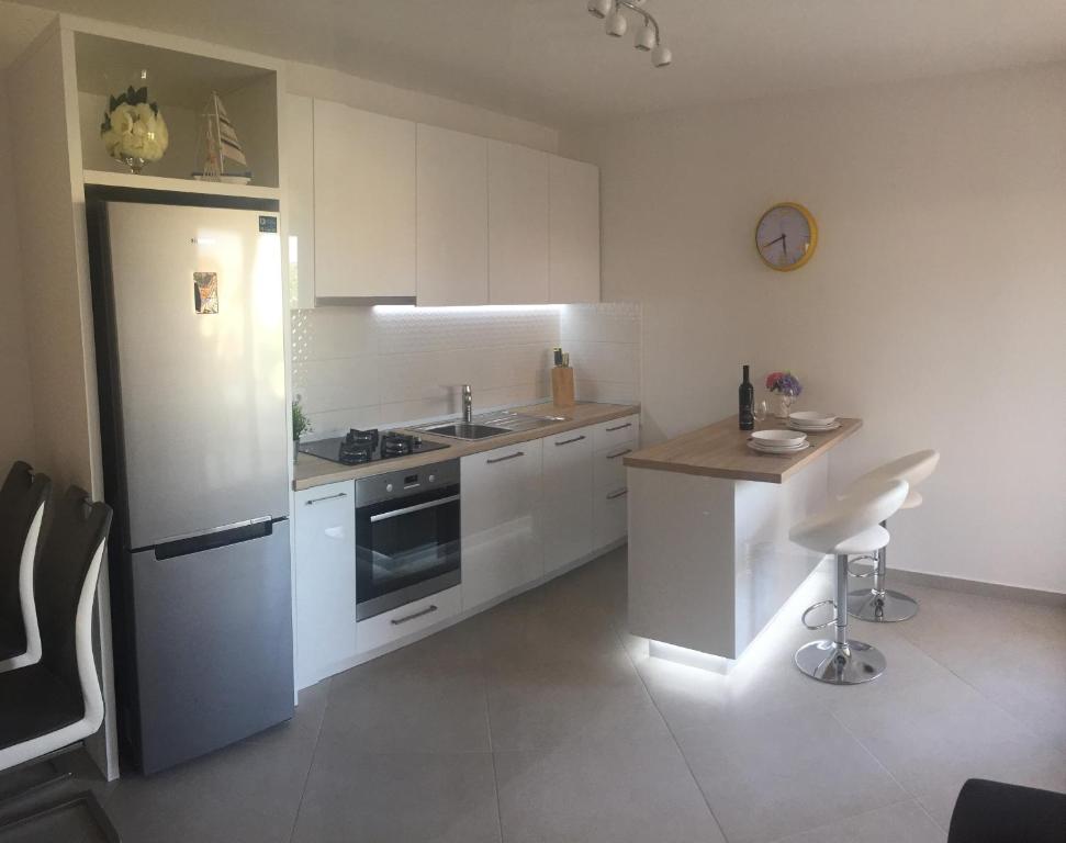 a kitchen with white cabinets and a sink and a counter at Apartmani Porat Malinska in Malinska