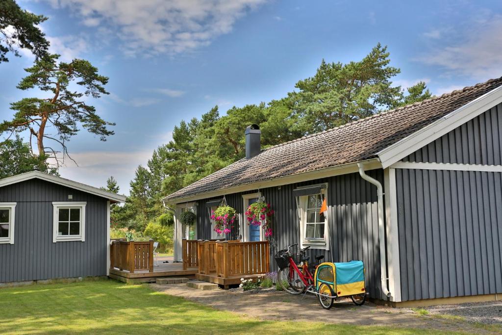 Villa near Åhus في Yngsjö: منزل به سطح و دراجة متوقفة في الخارج