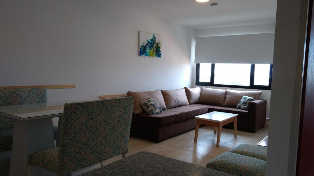 uma sala de estar com um sofá e uma mesa em Tu Hogar en Neuquen em Neuquén