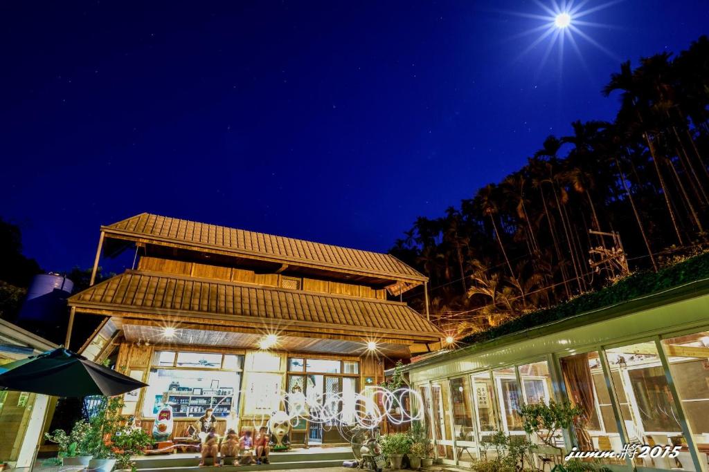 Ein Gebäude mit Leuten, die nachts draußen sitzen. in der Unterkunft Tian Xiu Mountain Village in Gukeng