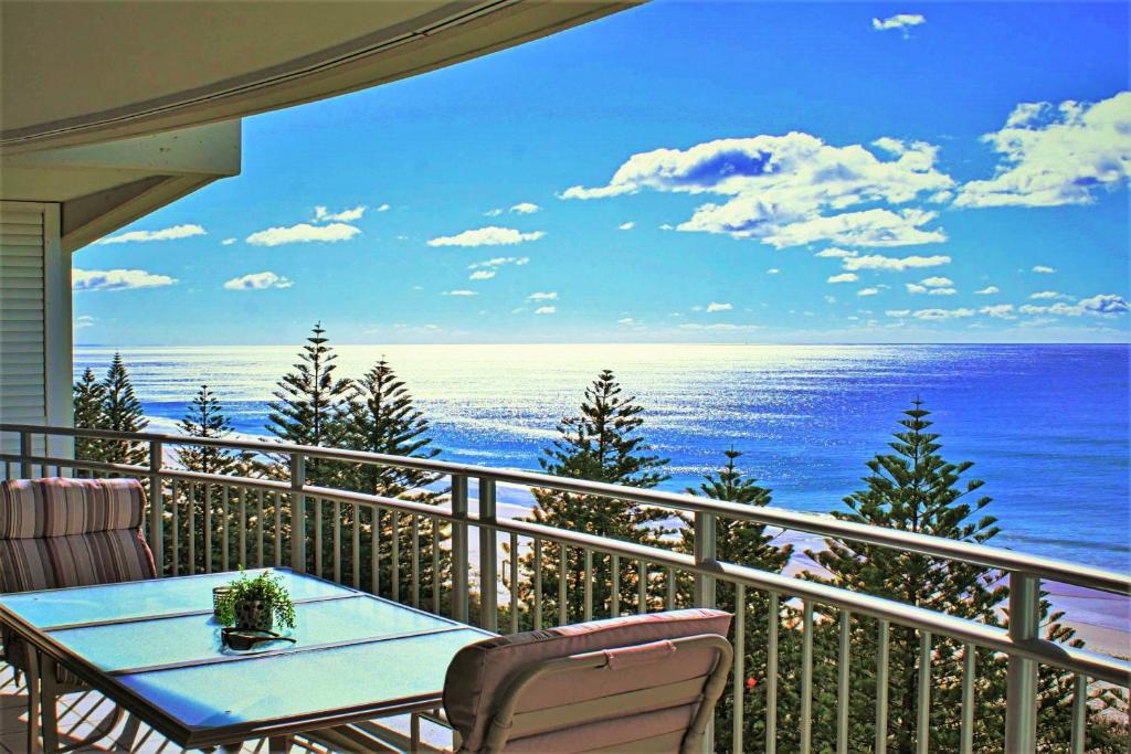 een balkon met een tafel en uitzicht op de oceaan bij Indigo Blue in Gold Coast