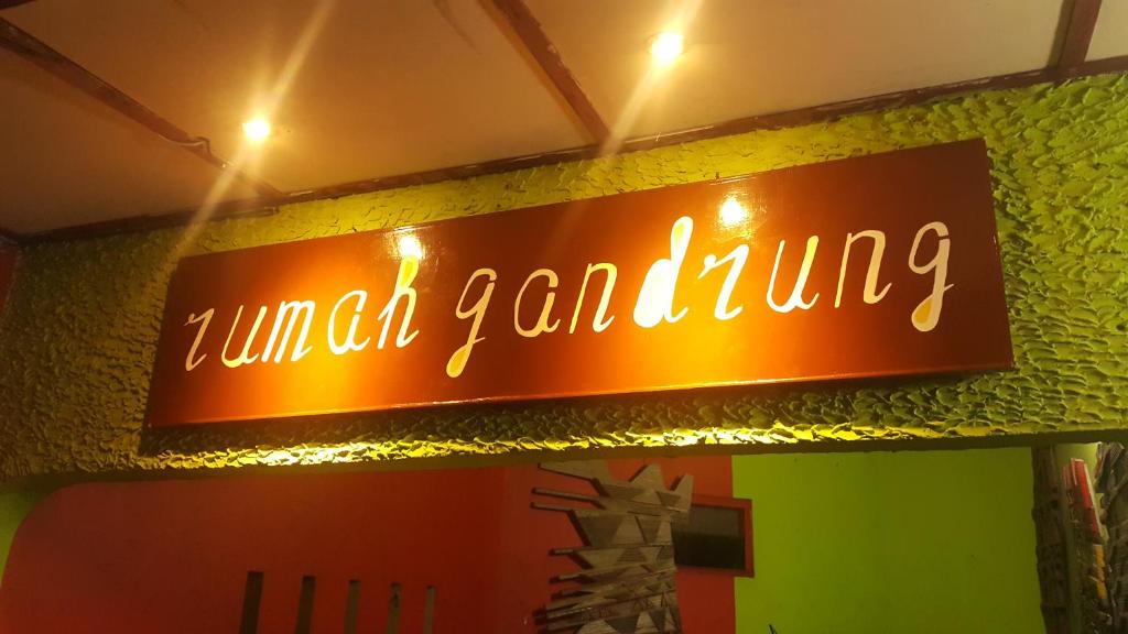ein Neonschild, das auf Zellgärten an der Wand steht in der Unterkunft Rumah Gandrung in Ngabean