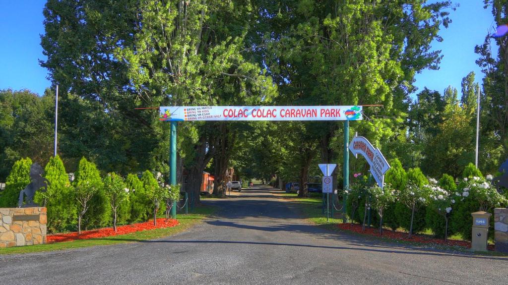 un cartel que lee Oak Creek Garden Park en Colac Colac Caravan Park, en Corryong