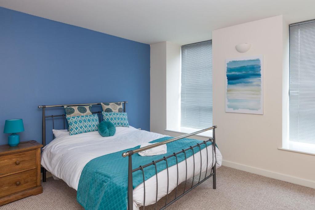 1 dormitorio con 1 cama con pared azul en Hicking Dye Works, en Nottingham