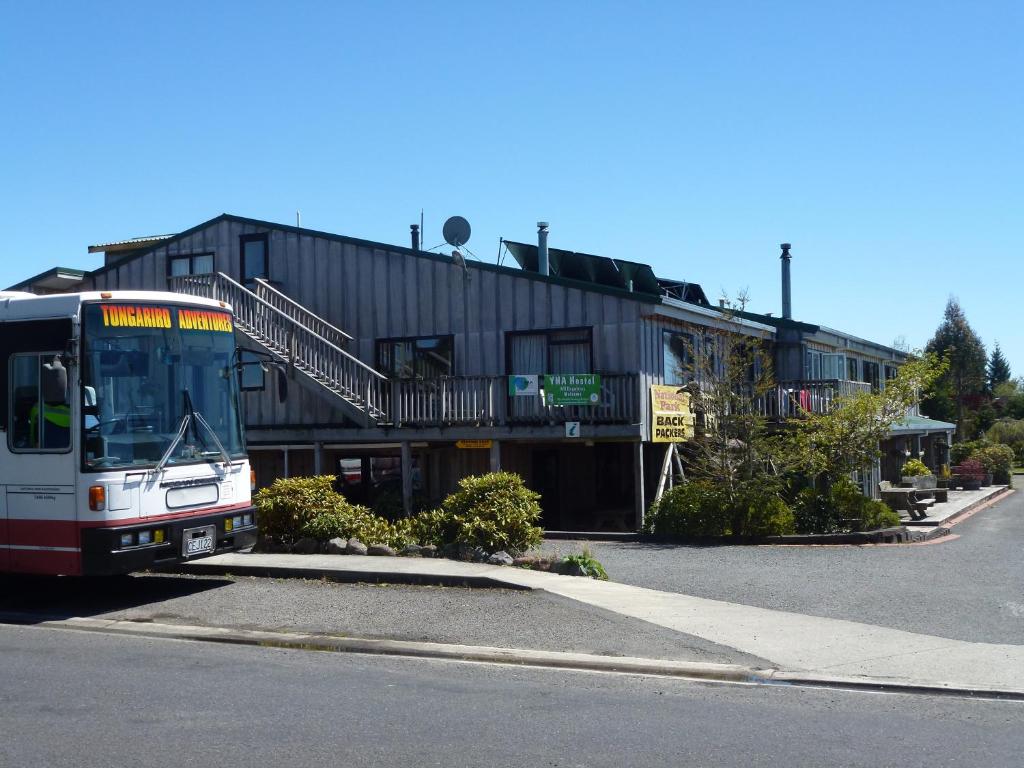um autocarro está estacionado em frente a um edifício em National Park Backpackers em National Park