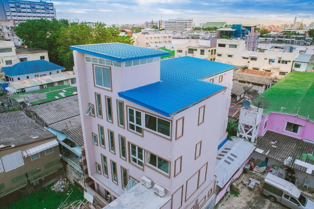 S.E.T Thanmongkol Residence في بانكوك: اطلالة علوية على مبنى ذو سقف ازرق
