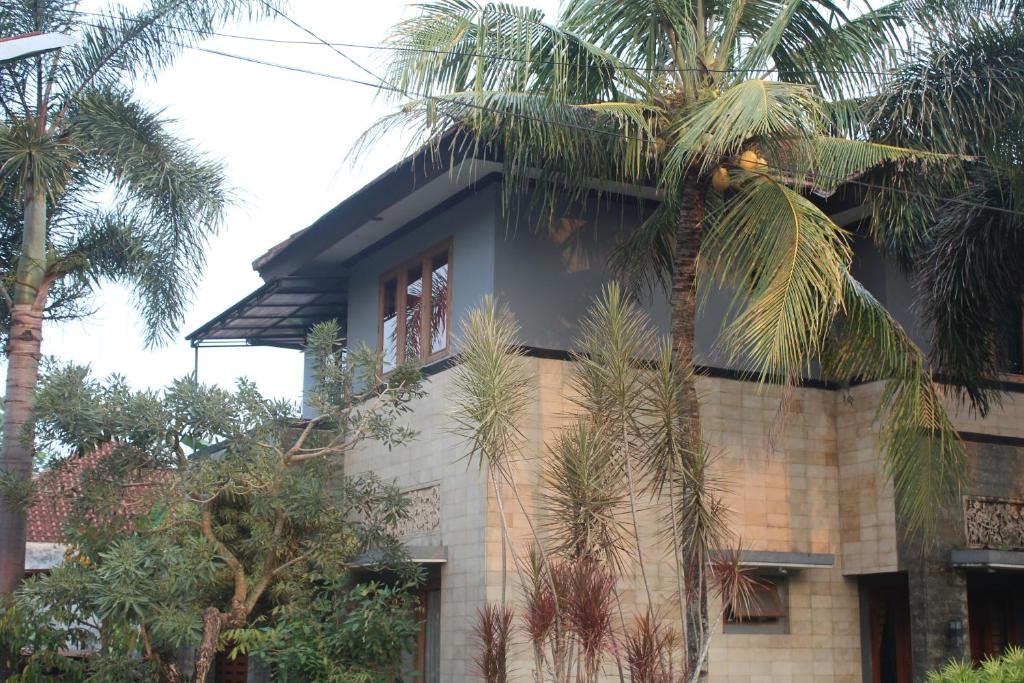 ジョグジャカルタにあるRabbani Family Homestayのヤシの木が目の前に広がる建物