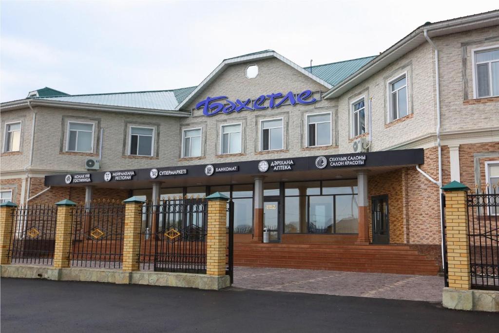 a building with a sign on the front of it at Hotel Bahetle in Ekibastuz