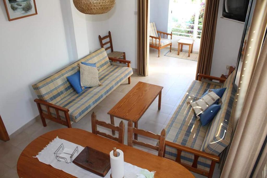 a living room with two couches and a table at Kaparris Apartment in Paralimni