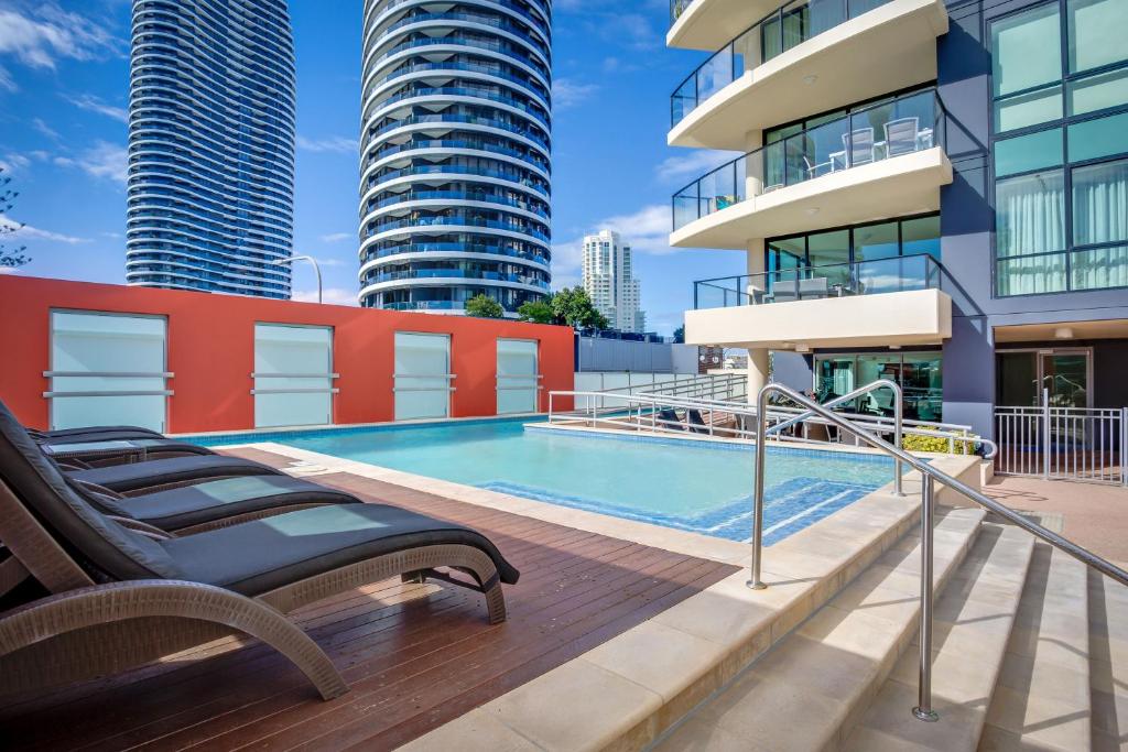 a swimming pool on the roof of a building with tall buildings at Mantra Broadbeach on the Park in Gold Coast