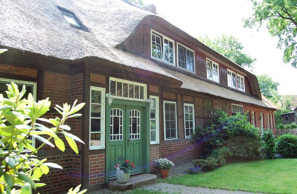 a large brick house with a thatched roof at Ferienwohnungen Wulfshof in Schneverdingen
