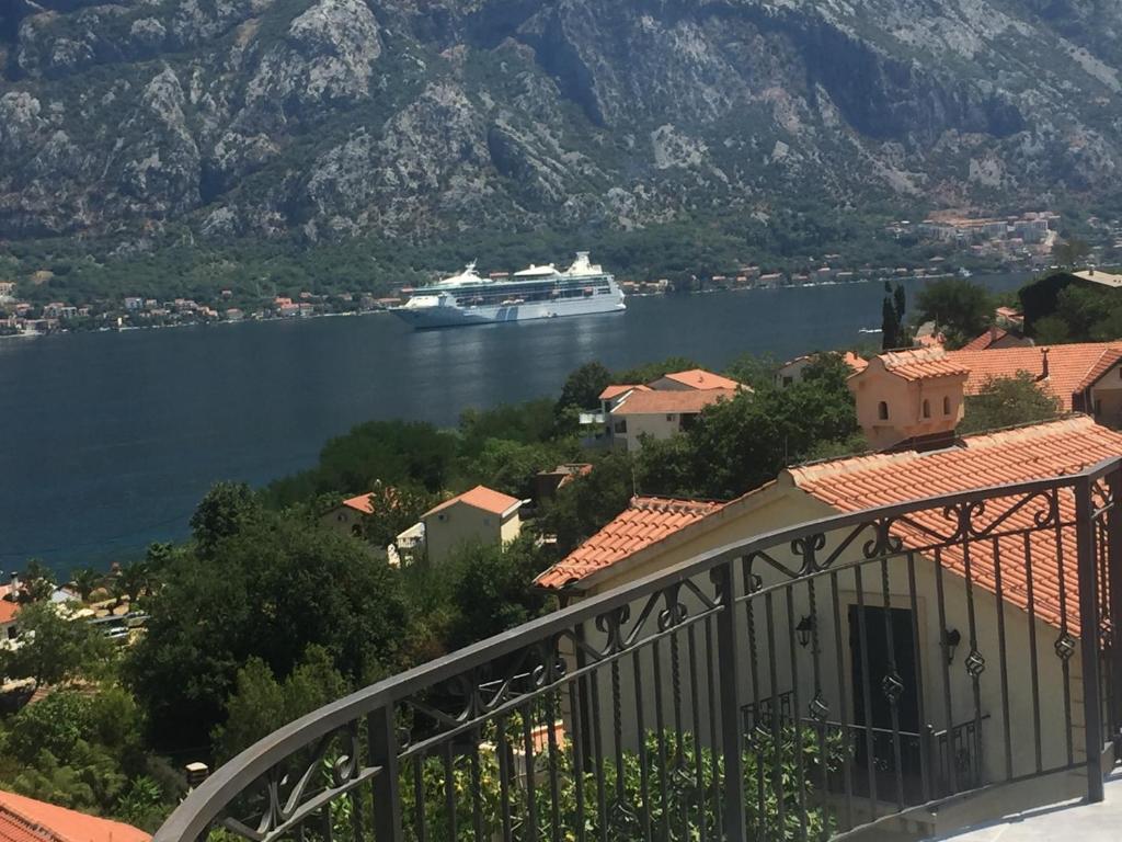 a cruise ship in a body of water with mountains at Luxury Apartments in Kotor