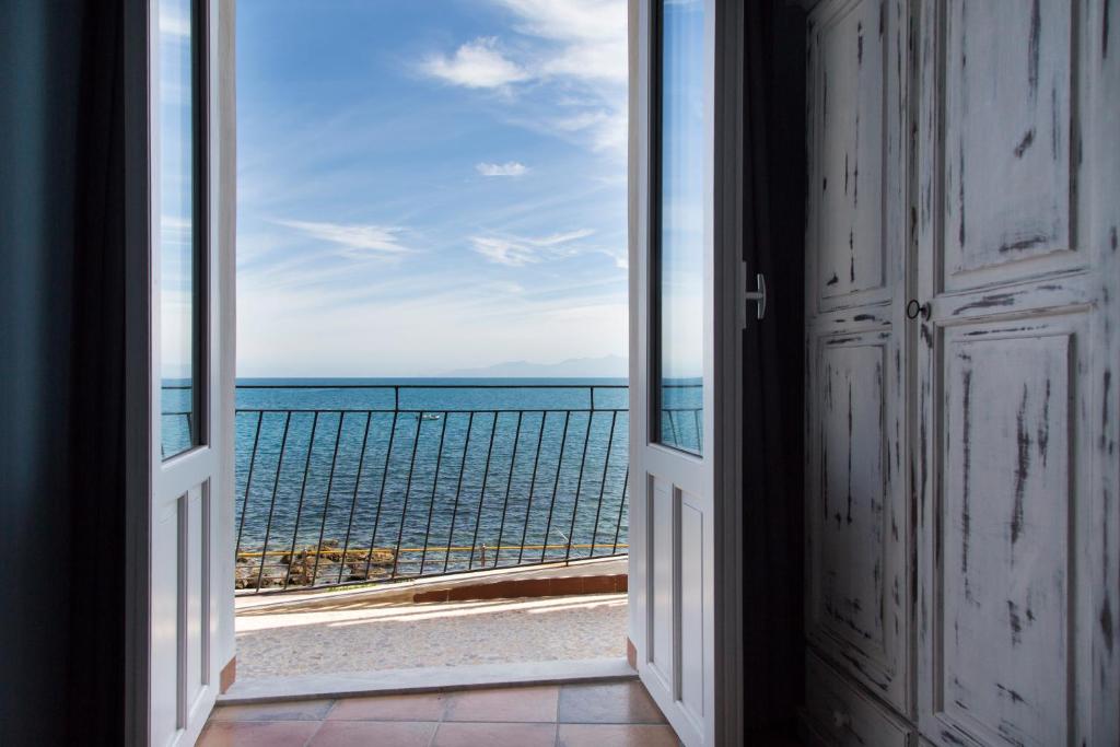 an open door with a view of the ocean at Nereidi in Santa Flavia
