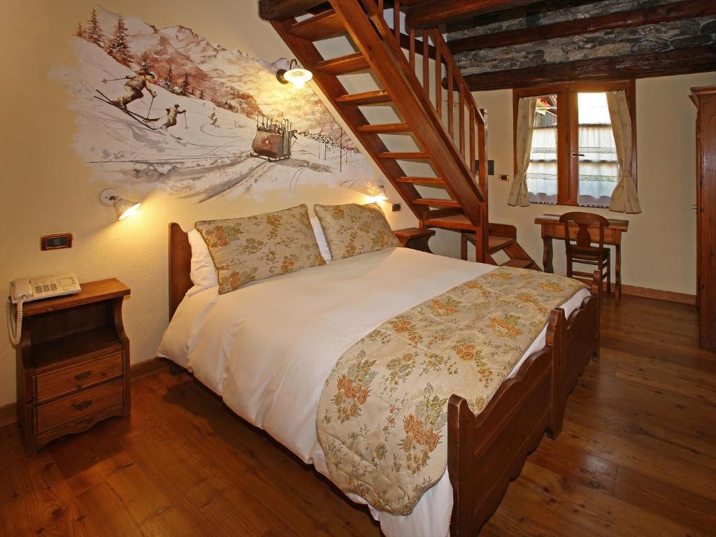 um quarto com uma cama e uma escada de madeira em Chalet Chez Nous em Sauze dʼOulx