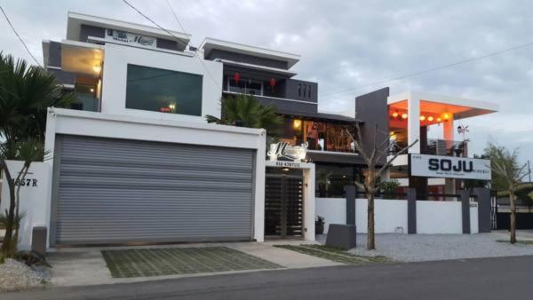 ein großes weißes Gebäude mit einer Roll-up-Garage in der Unterkunft Millenium maison home in Alor Setar