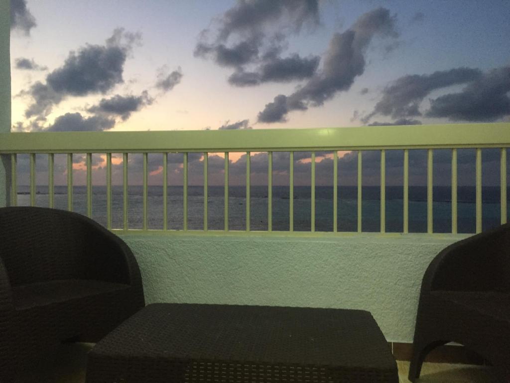 a balcony with a view of the ocean at sunset at Al-Madina Tower Apartment in Marsa Matruh