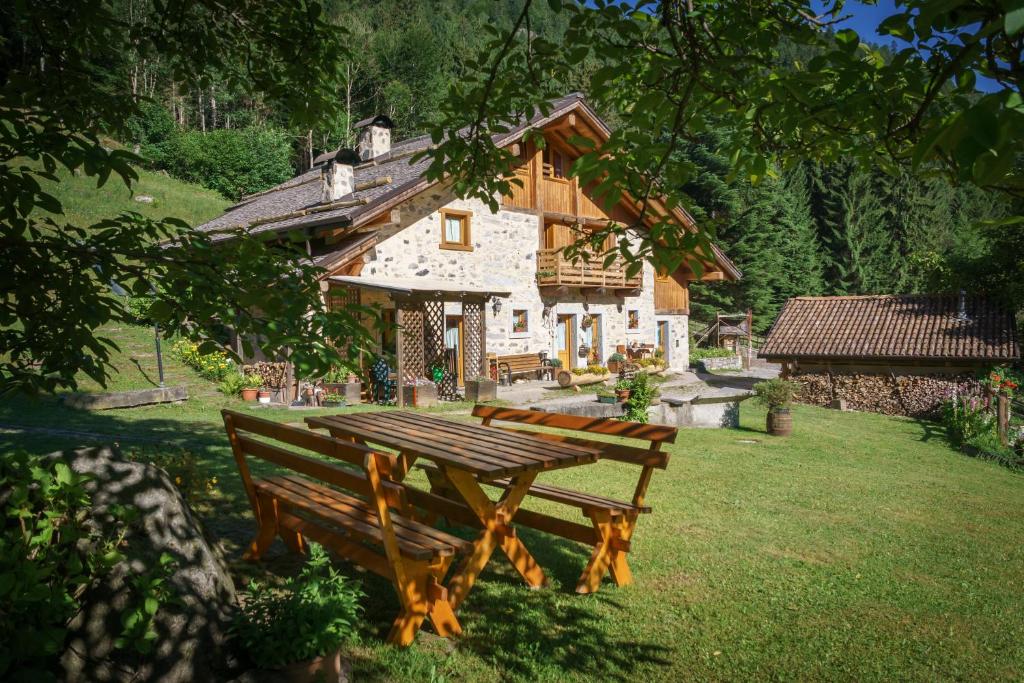 a wooden picnic table in front of a house at Agritur Manoncin in Daone