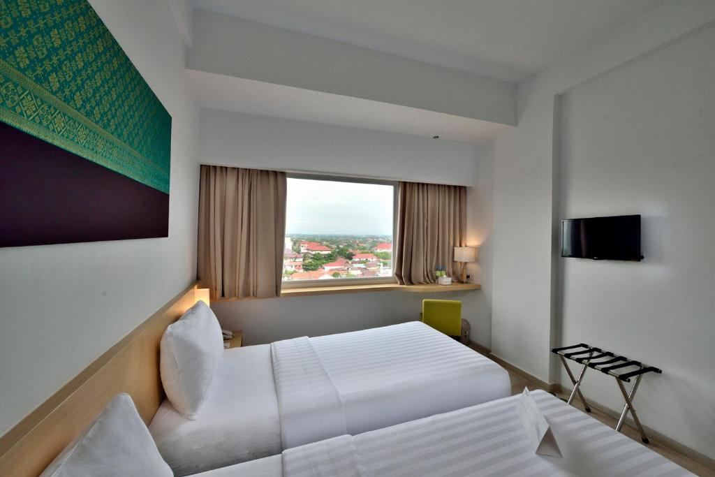 Postel nebo postele na pokoji v ubytování Whiz Prime Hotel Sudirman Pekanbaru