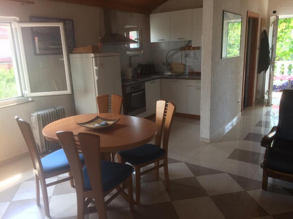 een keuken en eetkamer met een tafel en stoelen bij Dragica Apartments in Vrsi