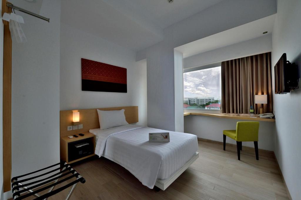 Postel nebo postele na pokoji v ubytování Whiz Prime Hotel Sudirman Pekanbaru