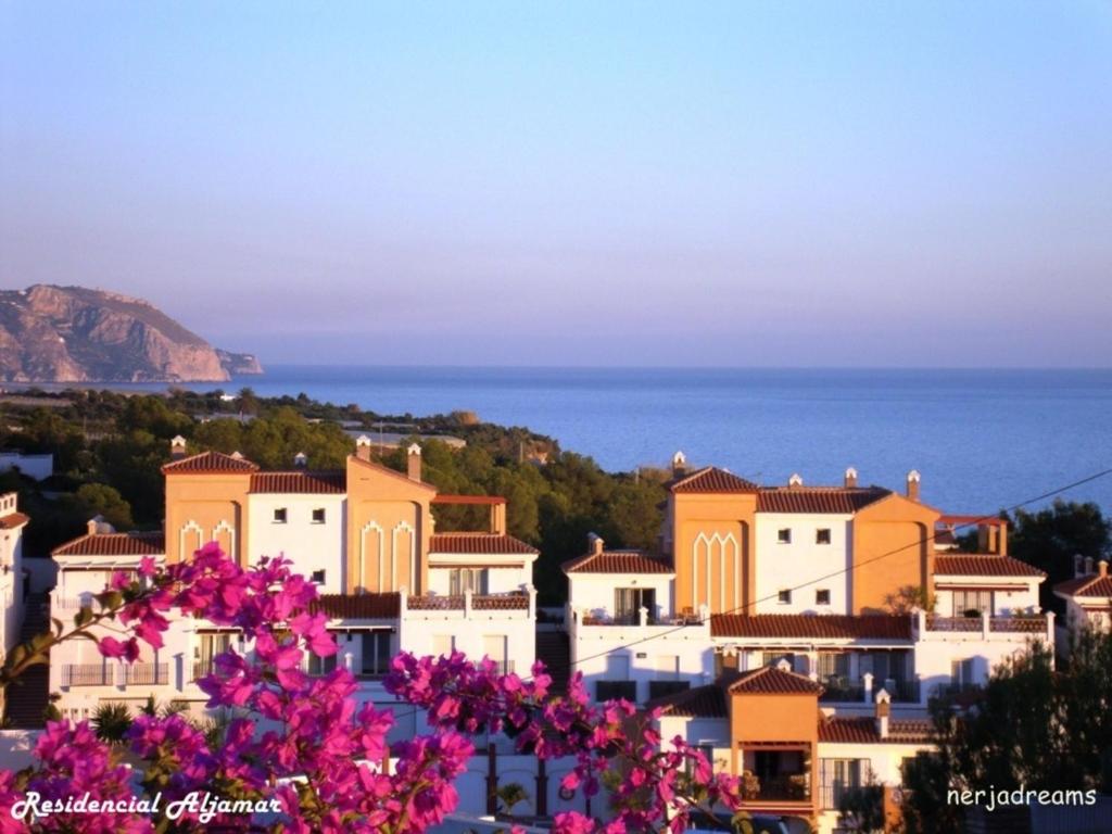 widok na miasto z różowymi kwiatami w obiekcie Aljamar 3B w mieście Nerja