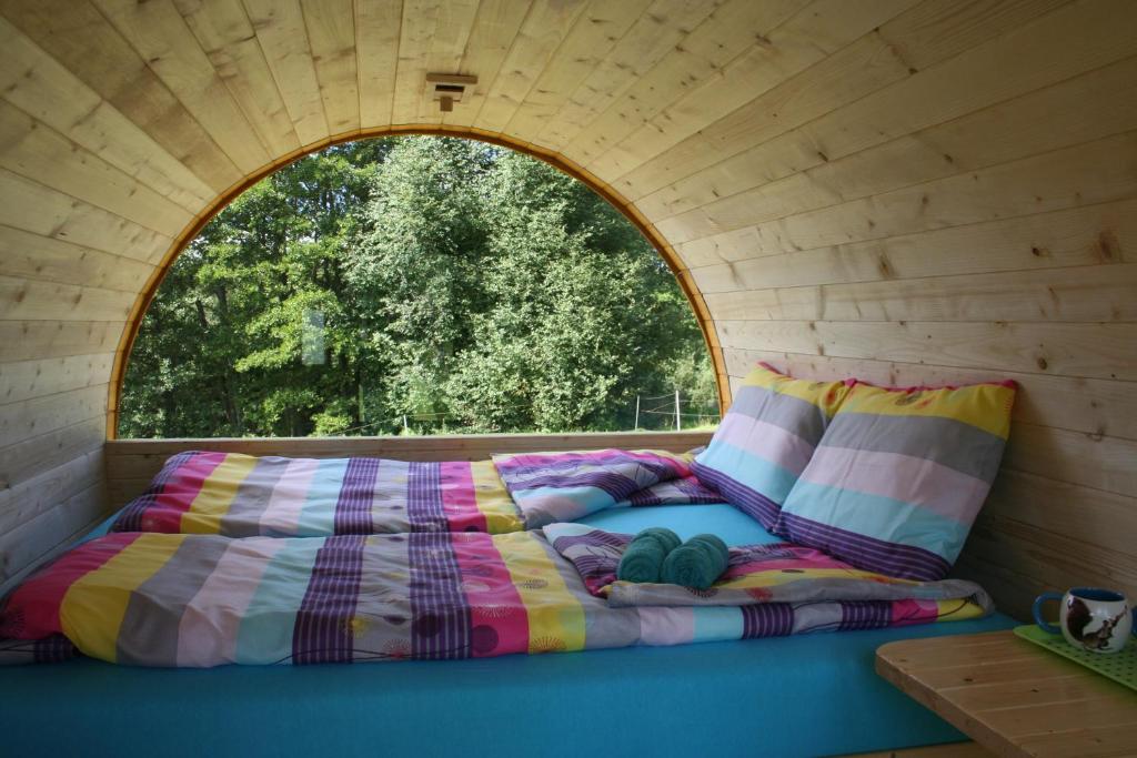 a bed in a tiny house with a window at Grāveri kempings in Usma