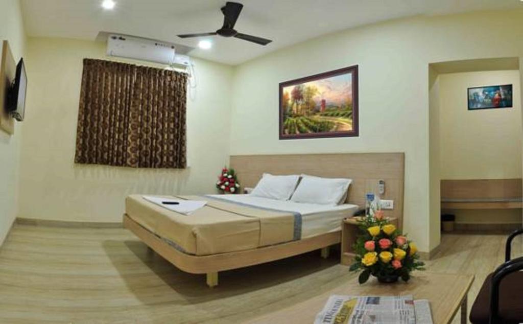 ein Schlafzimmer mit einem Bett und einem Wandgemälde in der Unterkunft SK Residency Unit 2 in Coimbatore