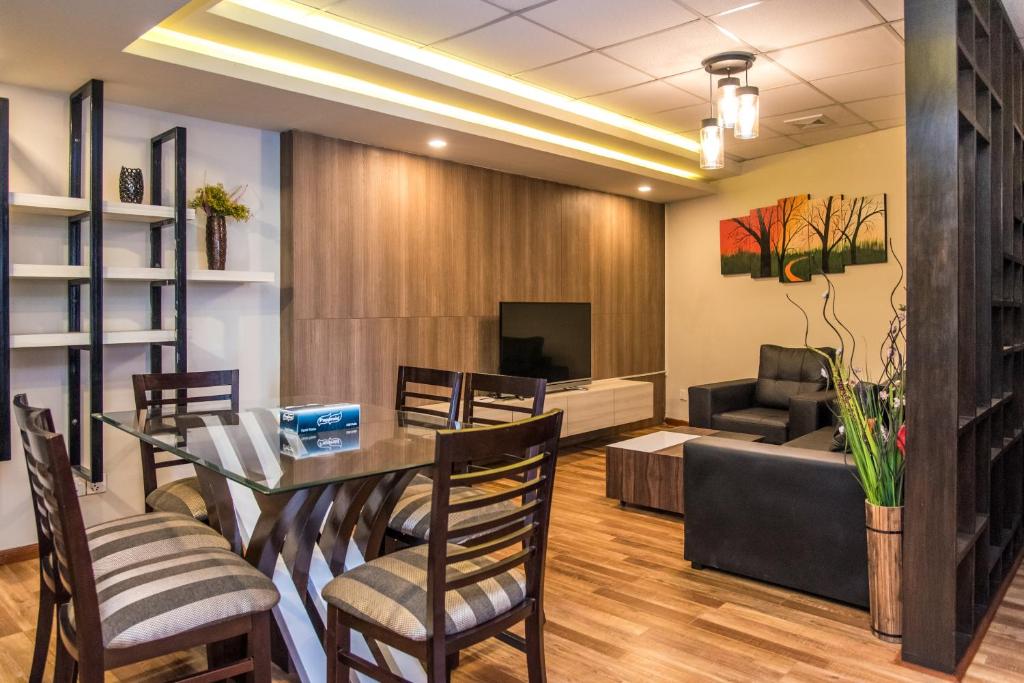 Classic Serviced Apartments في Jawlakhel: غرفة طعام مع طاولة وكراسي وأريكة