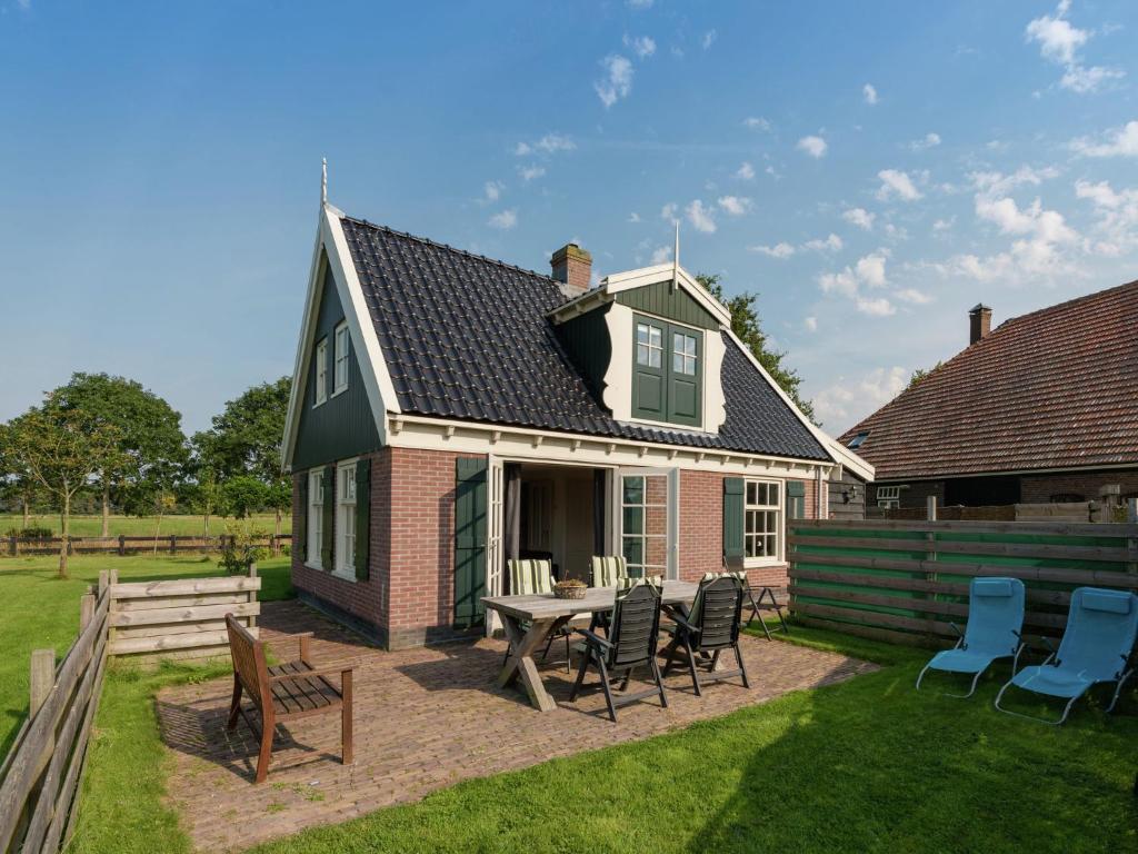 Holiday home on former island Wieringen في Oosterklief: منزل به طاولة وكراسي في الفناء