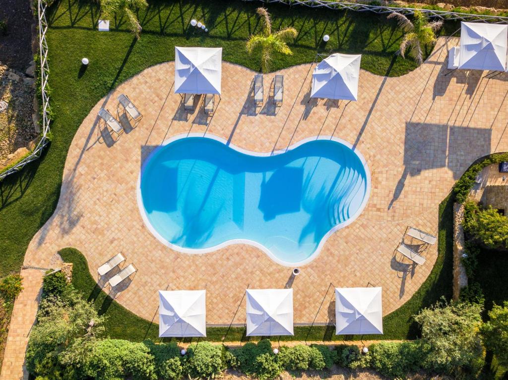 an overhead view of a swimming pool with chairs and umbrellas at Agriturismo Feudo Muxarello in Aragona