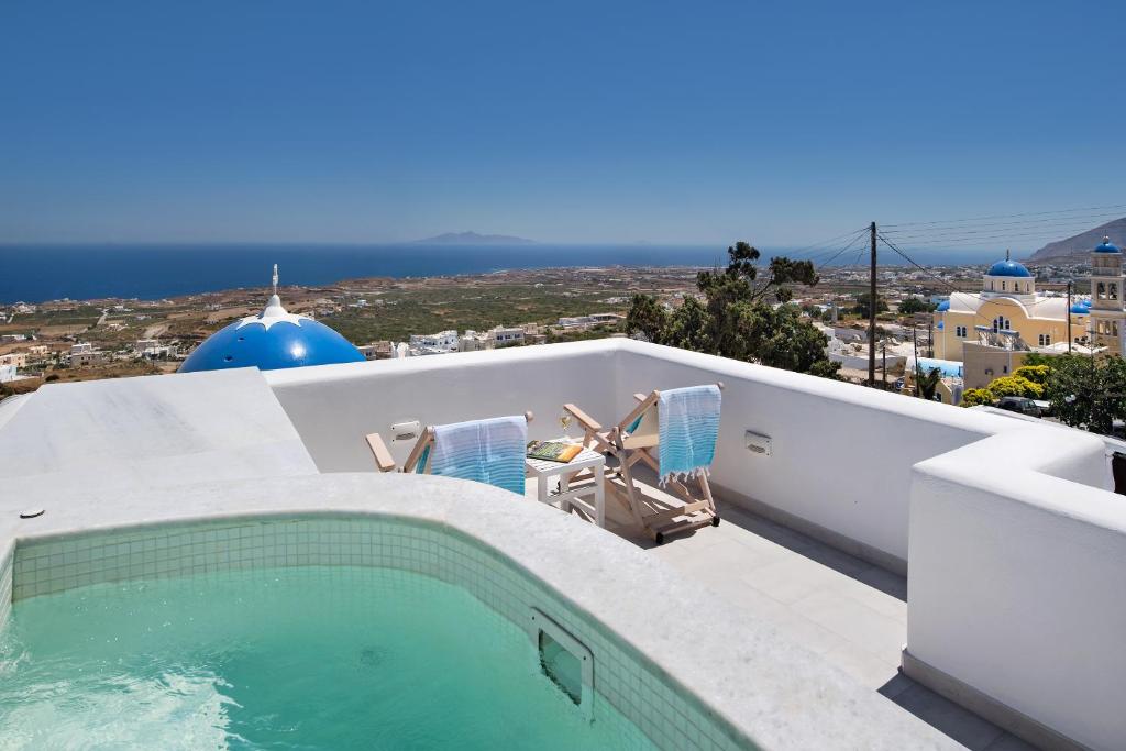 a swimming pool on the roof of a house at Altemar Suites in Fira