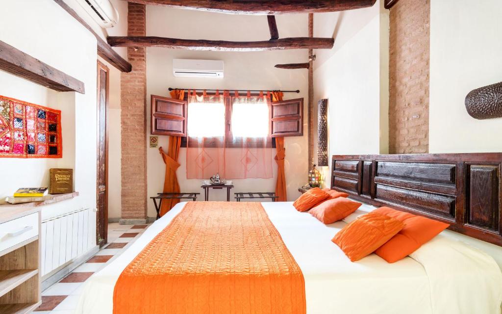 a bedroom with a large bed with orange pillows at Casa de Federico Boutique in Granada